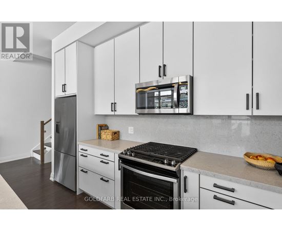 A kitchen with white cabinets and a black stove top.
