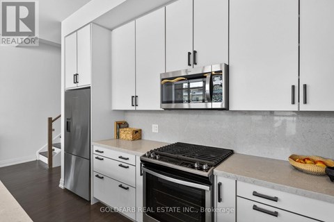 A kitchen with white cabinets and a black stove top.