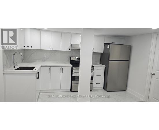 A kitchen with white cabinets and a refrigerator.