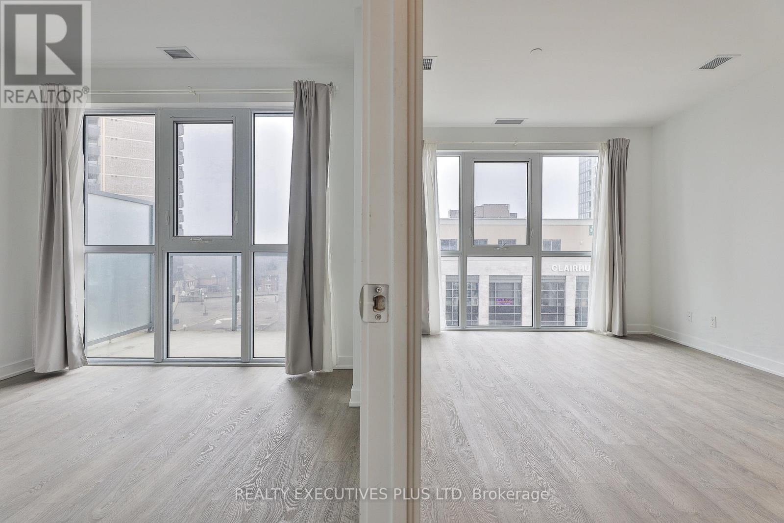 A spacious room with a view of the city through large windows.