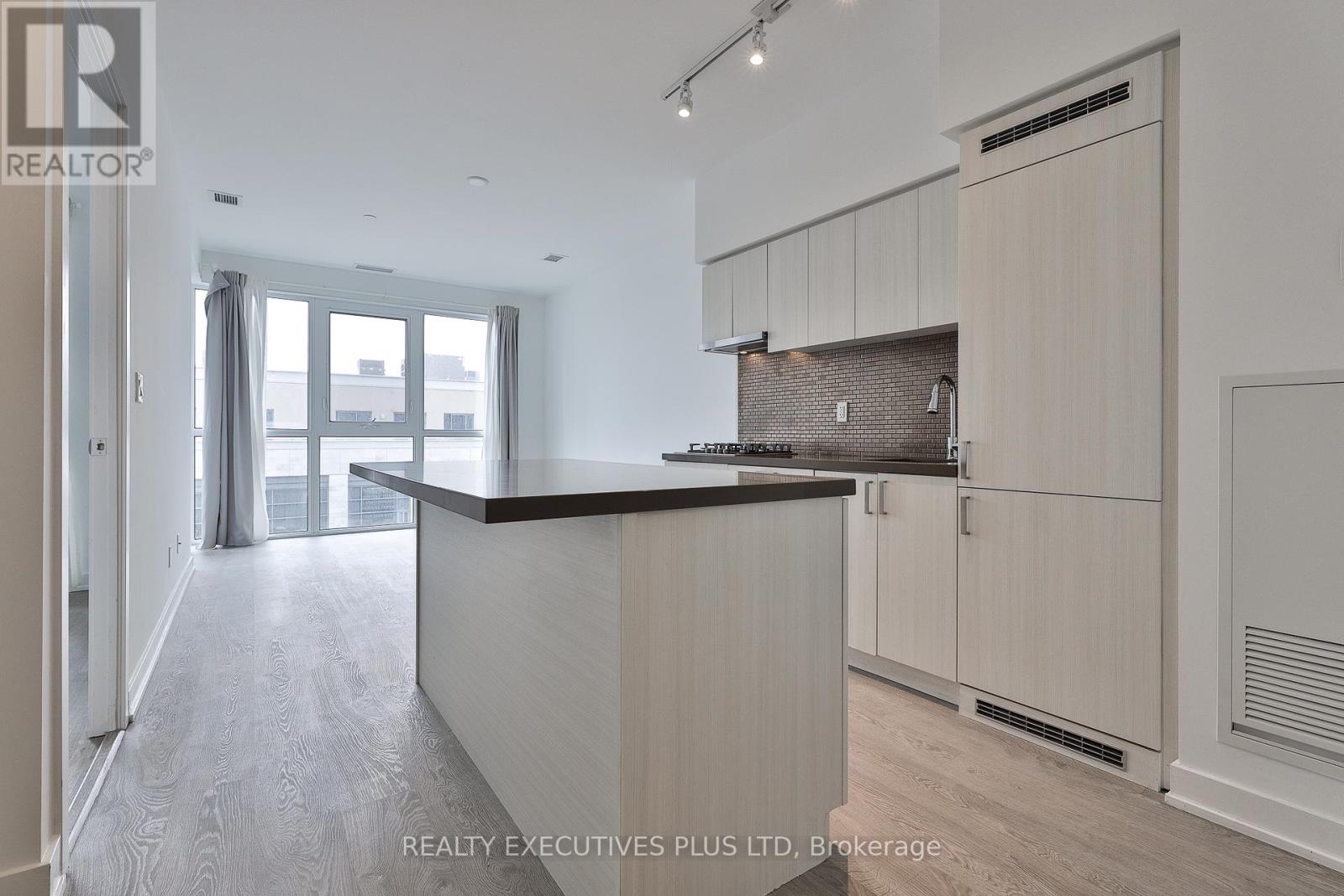 A modern kitchen with wooden cabinets and a large island.