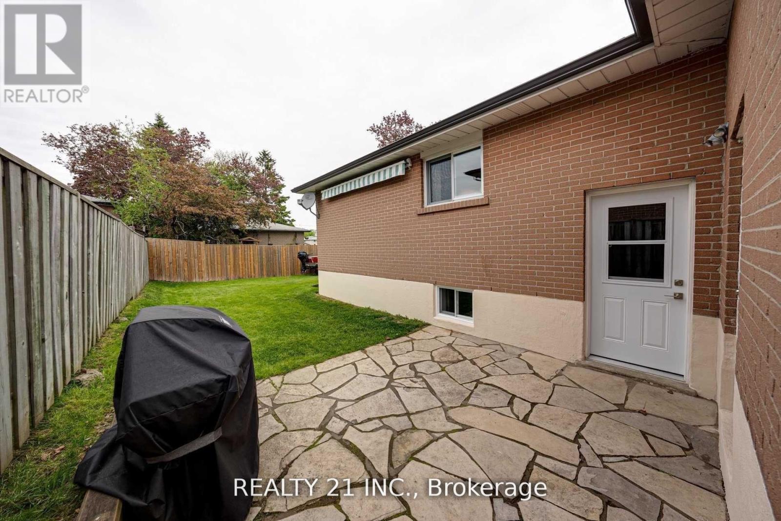 A brick house with a patio and a grill cover.