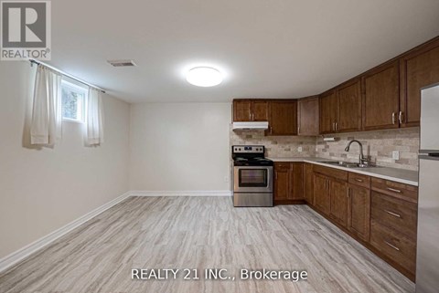 A kitchen with wooden cabinets and a stainless steel oven.