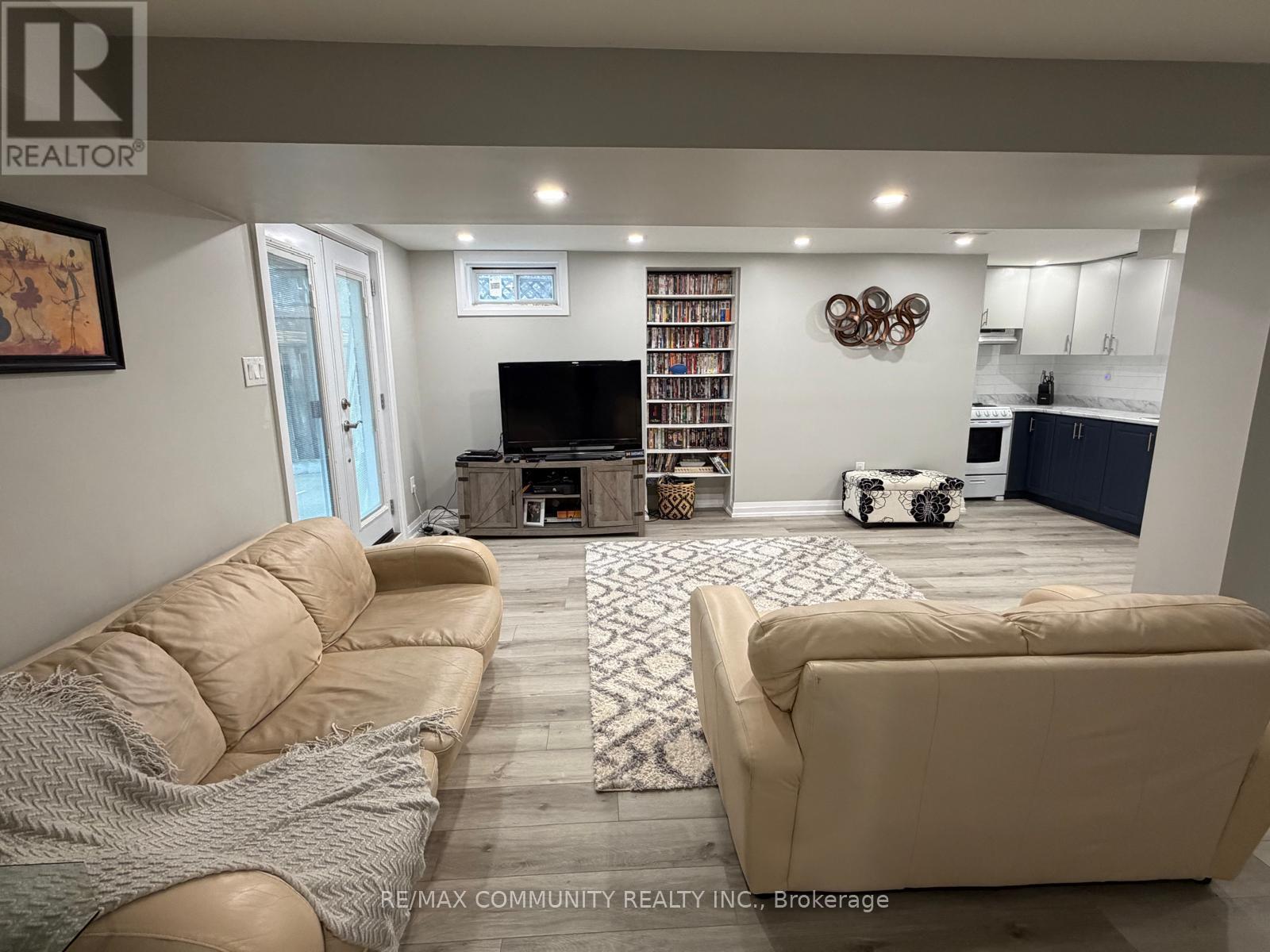 A living room with a beige couch and a flat screen TV.