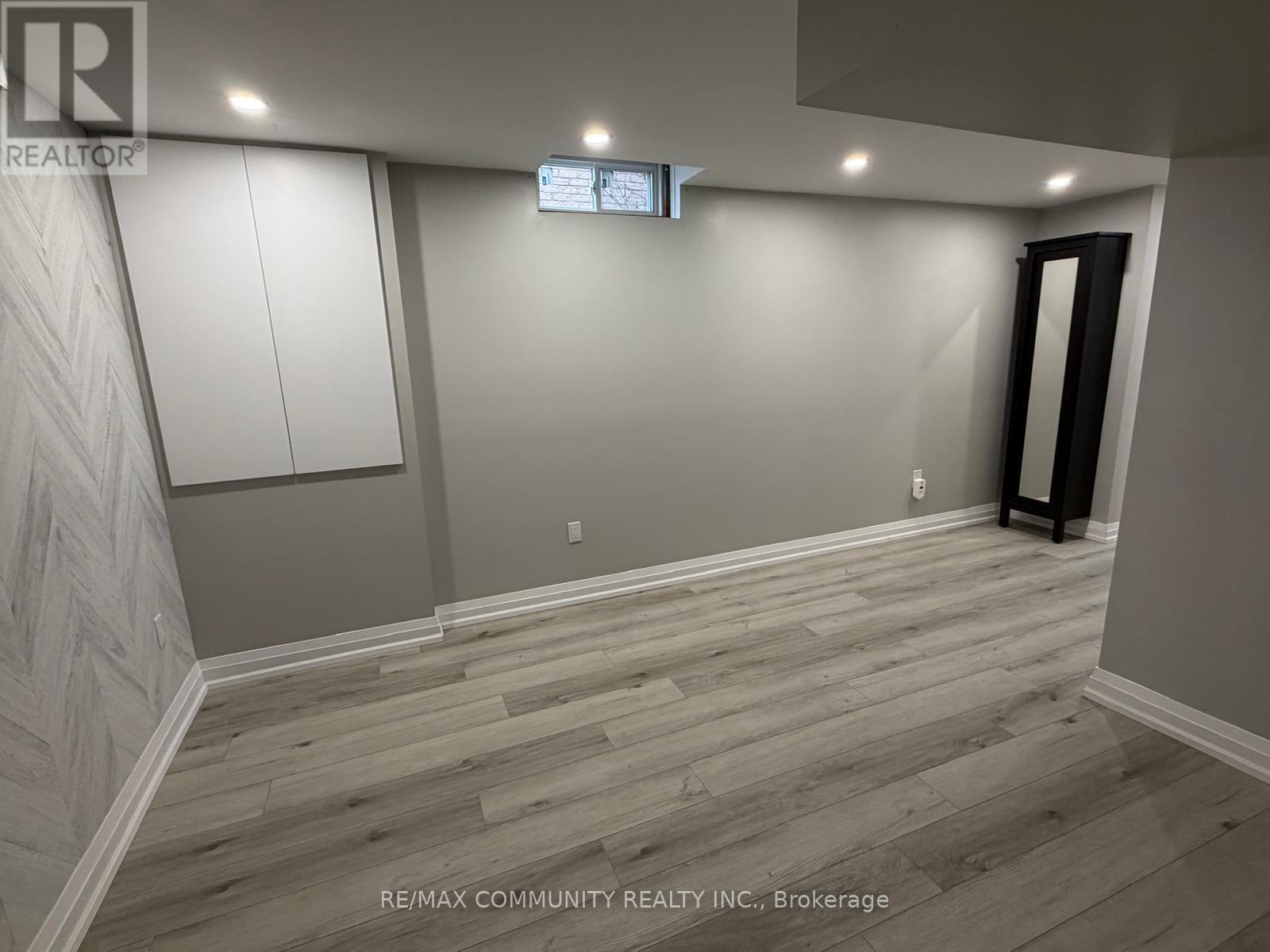 A room with wooden flooring and a wall with a herringbone pattern.