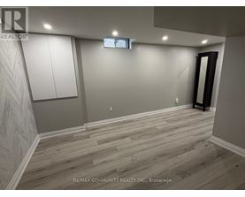 A room with wooden flooring and a wall with a herringbone pattern.