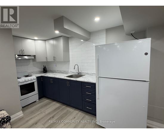 A kitchen with white appliances and dark blue cabinets.