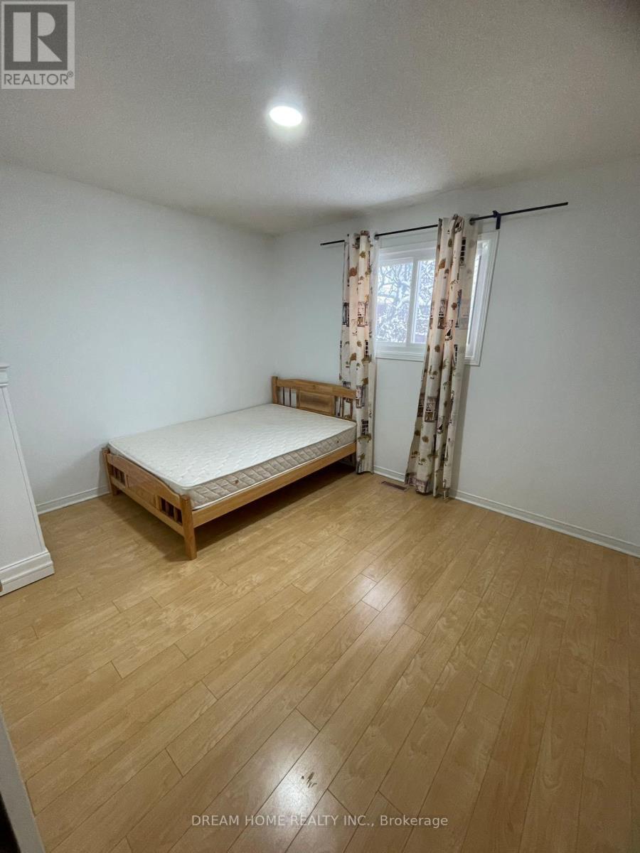 A bedroom with a bed and wooden flooring.