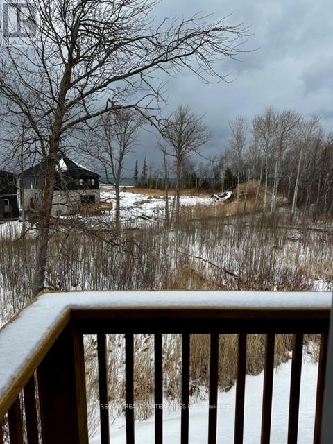 A snowy landscape with a house and bare trees.