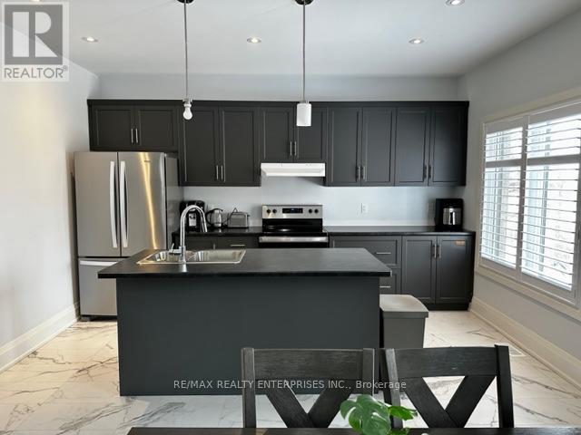 A modern kitchen with a large island and stainless steel appliances.