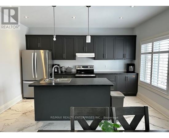 A modern kitchen with a large island and stainless steel appliances.