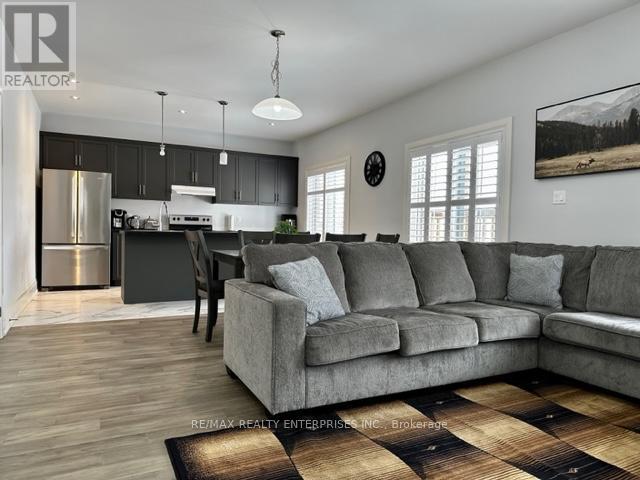 A living room with a grey couch and a wooden floor.