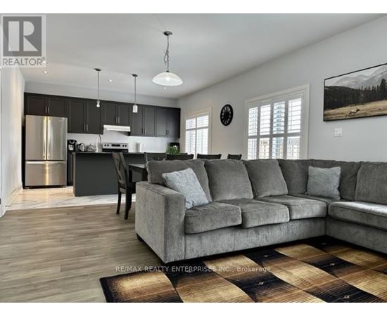 A living room with a grey couch and a wooden floor.
