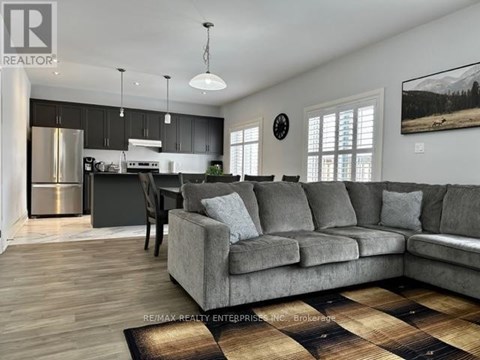 A living room with a grey couch and a wooden floor.