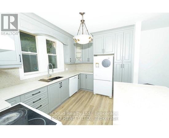 A kitchen with white cabinets and a white fridge.
