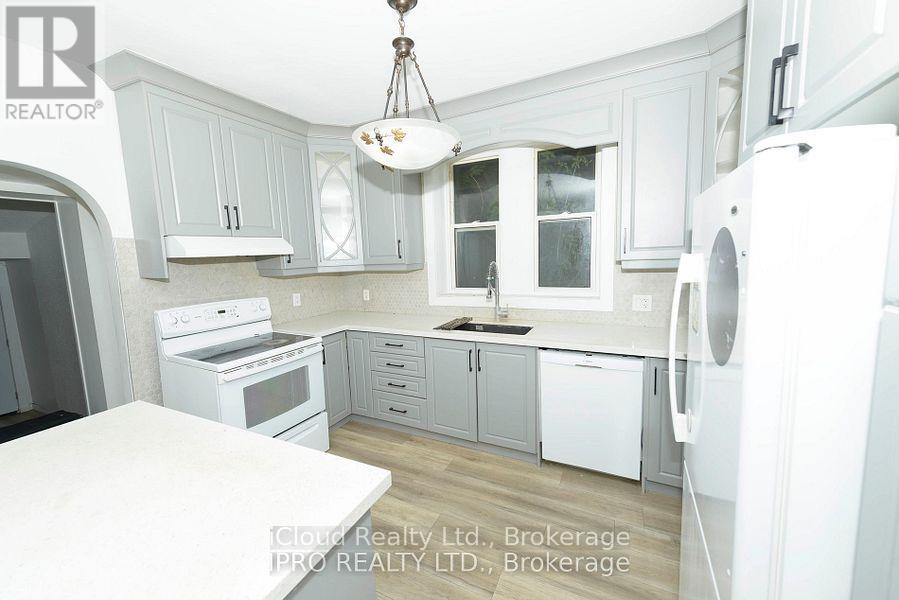 A kitchen with white appliances and grey cabinets.