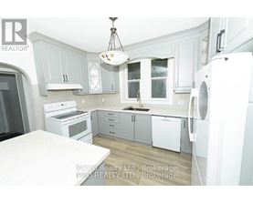 A kitchen with white appliances and grey cabinets.