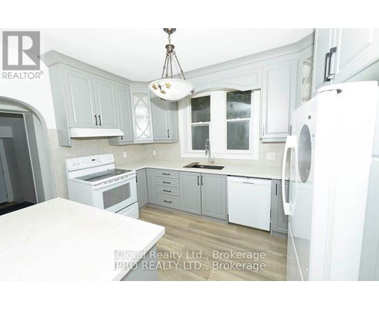 A kitchen with white appliances and grey cabinets.