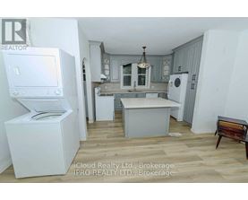 A kitchen with white appliances and wooden floors.