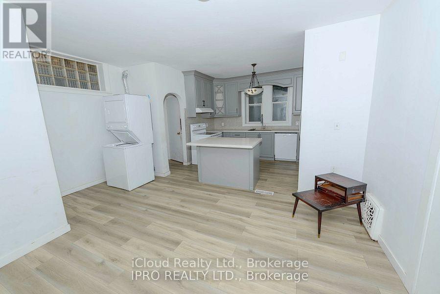 A kitchen with a refrigerator, sink, and cabinets.