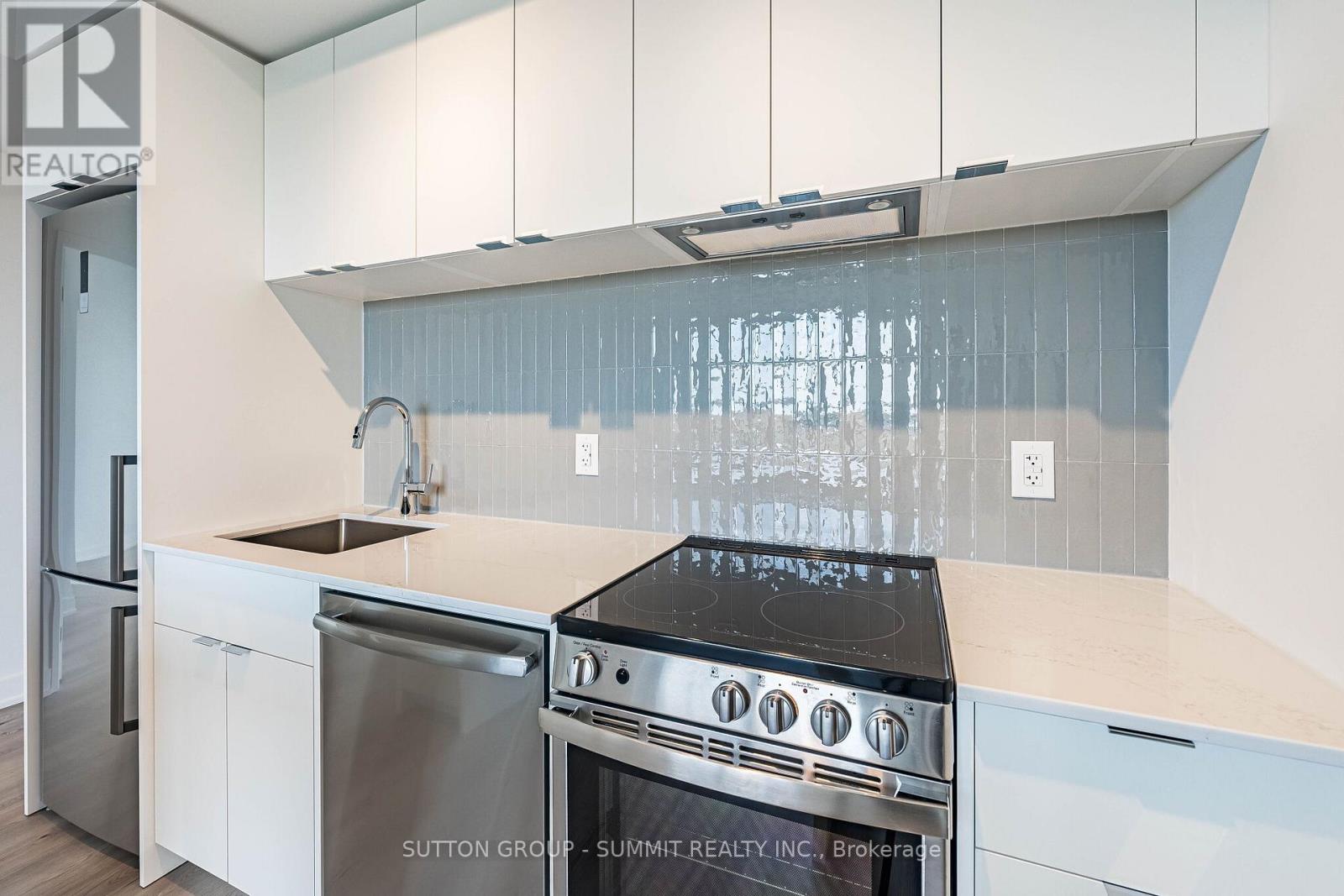 A modern kitchen with white cabinets and stainless steel appliances.