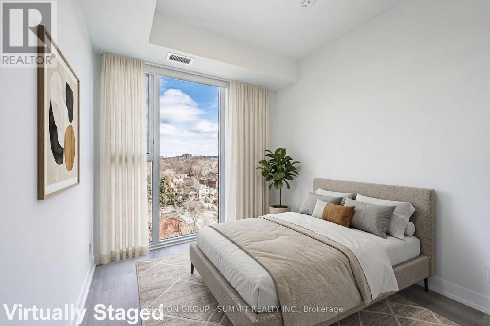 A bedroom with a large bed and a view of the outdoors through a sliding glass door.