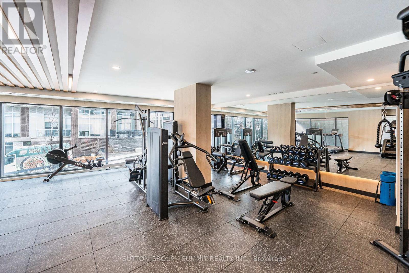 A gym with a variety of equipment including weights and cardio machines.