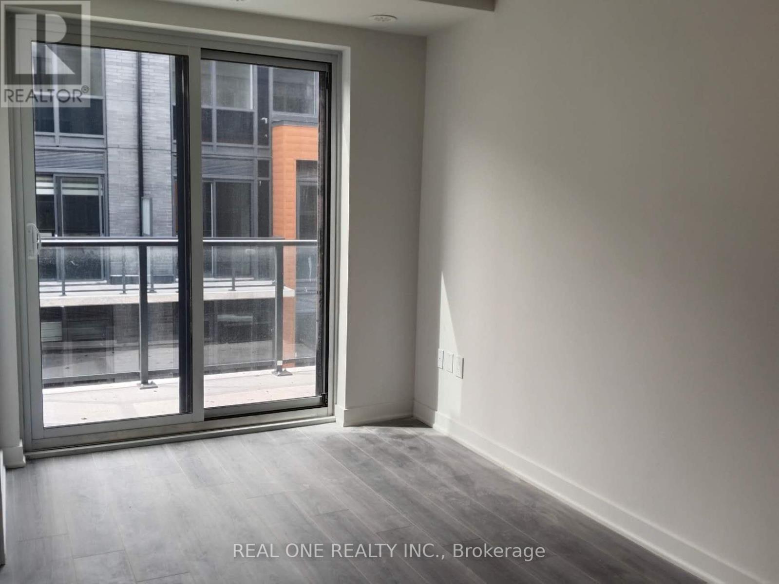 A room with a sliding glass door leading to a balcony.