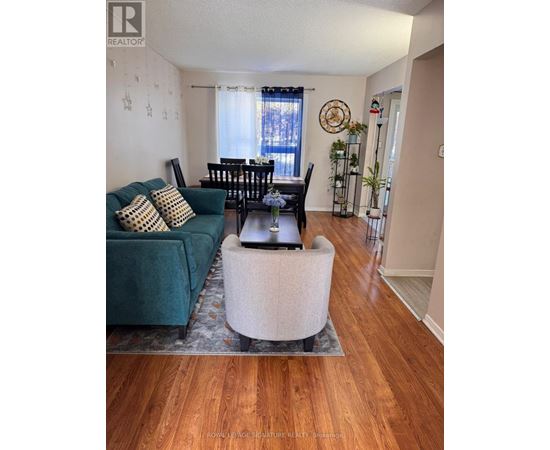 A living room with a green couch and a wooden floor.