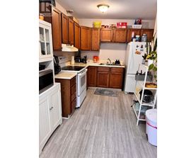 A kitchen with wooden cabinets and a white refrigerator.