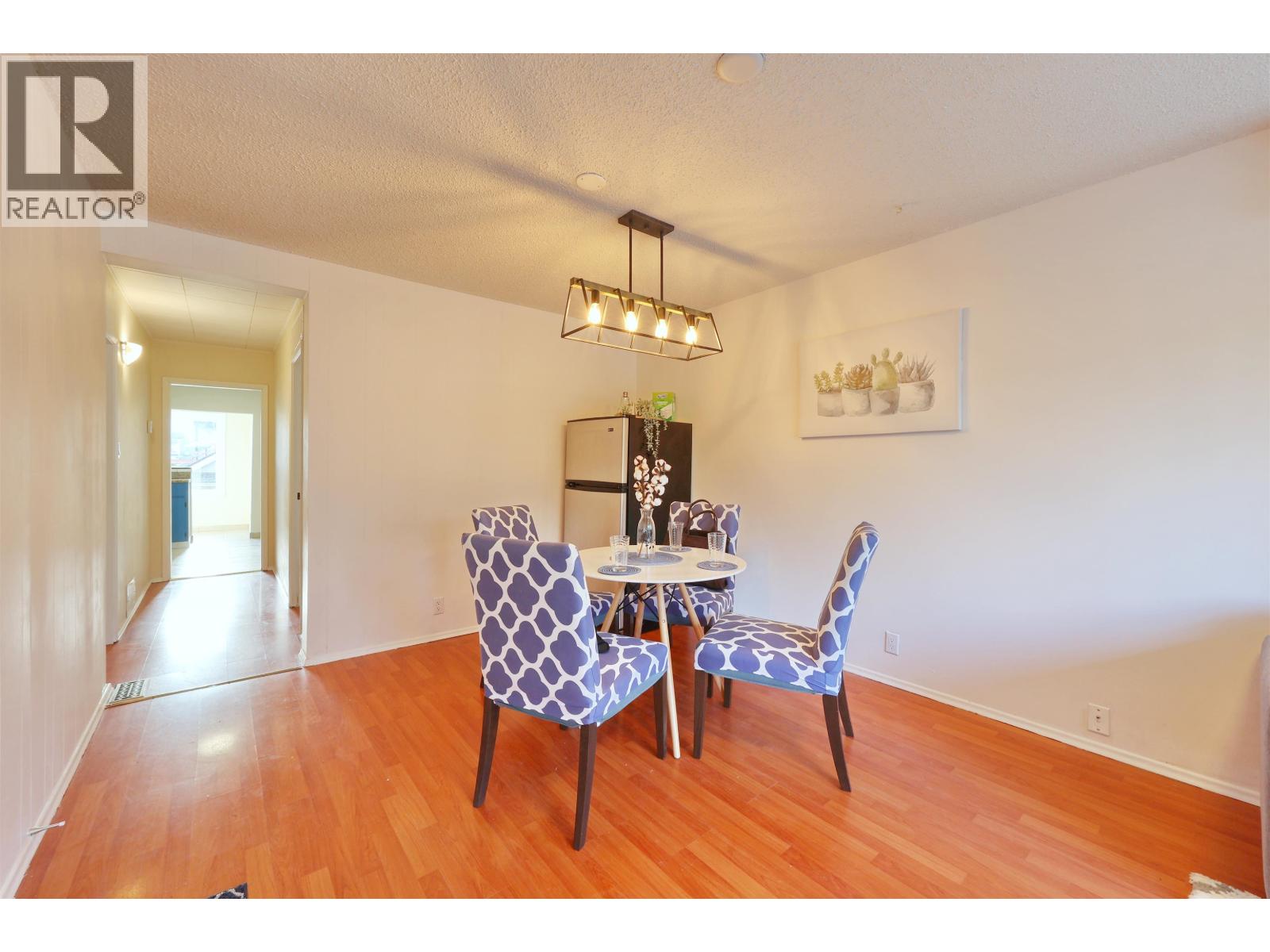 A dining room with a table and chairs.