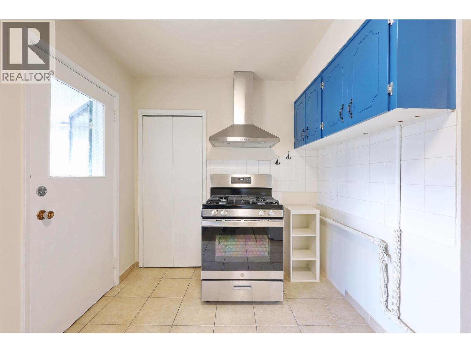 A kitchen with a stove and a refrigerator.