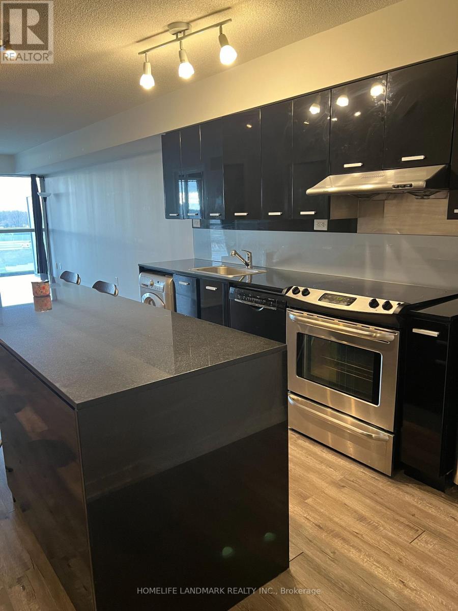 A modern kitchen with black cabinets and stainless steel appliances.