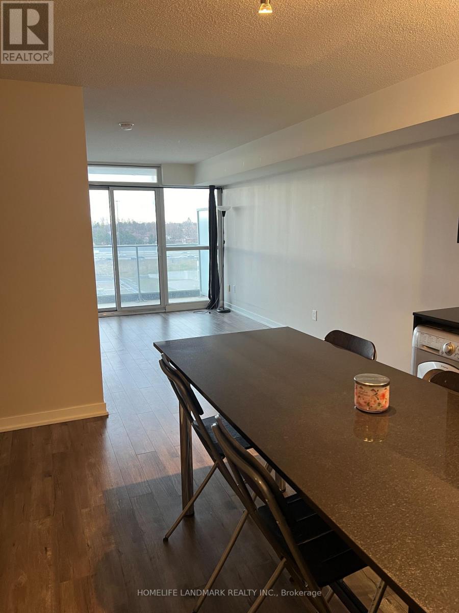 A table with a container on it sits in a room with a view of a parking lot through a glass door.