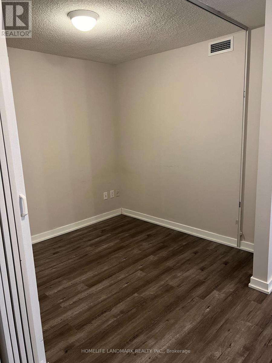 A room with wood flooring and a door on the right side.