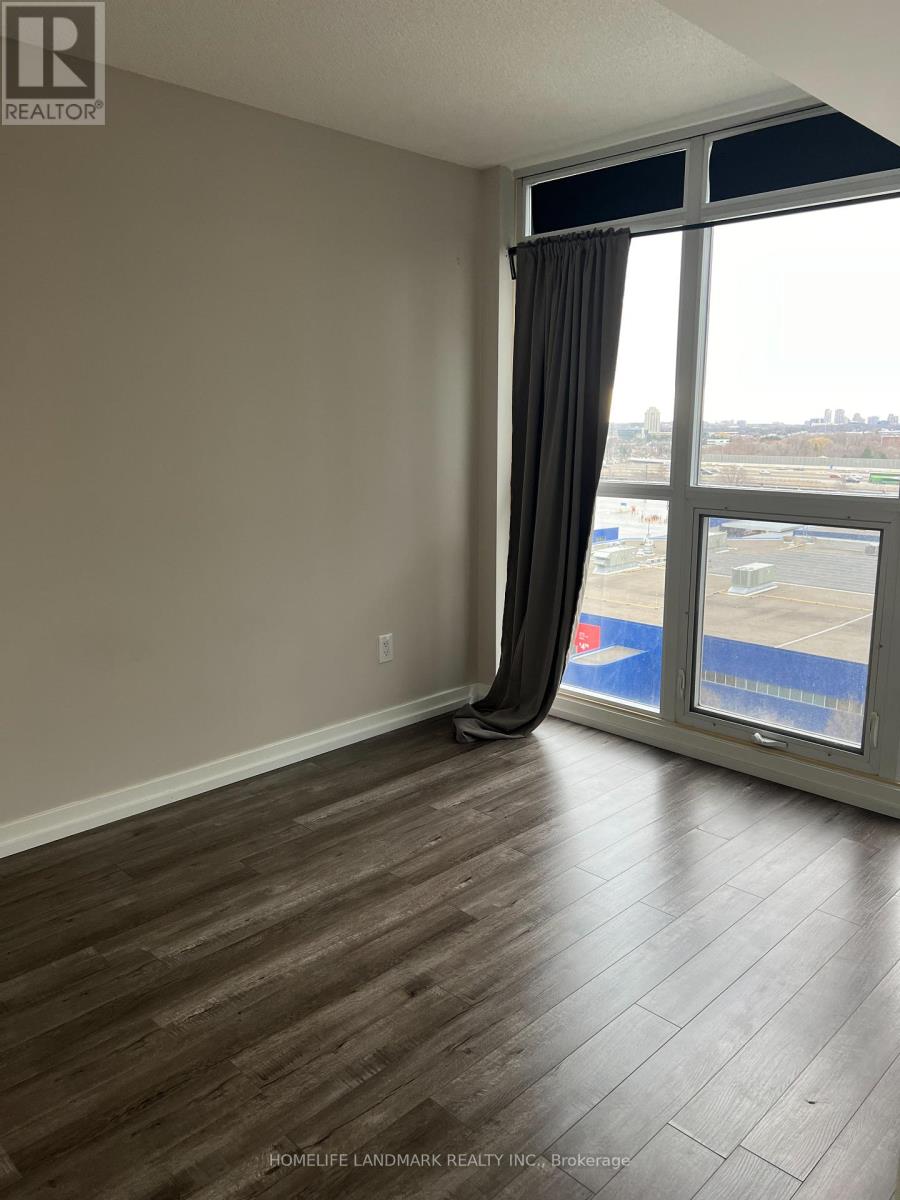 A room with a large window and a view of a parking lot.
