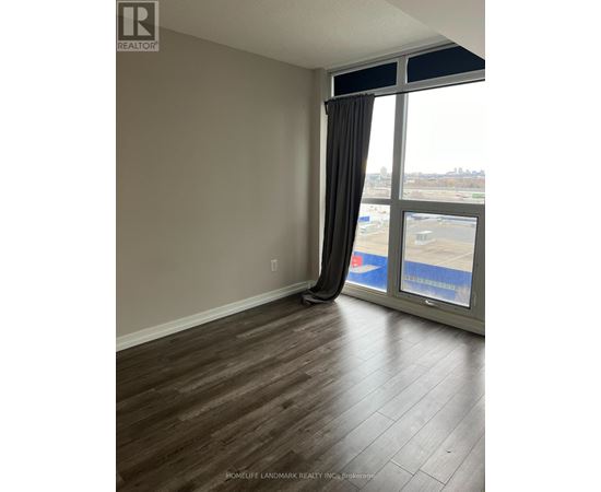 A room with a large window and a view of a parking lot.