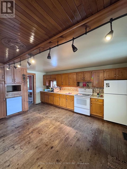 A kitchen with wooden cabinets and a white refrigerator.