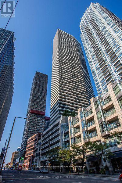 A city street with a tall building in the middle and a sign that says RE/MAX Real Estate Centre Inc.