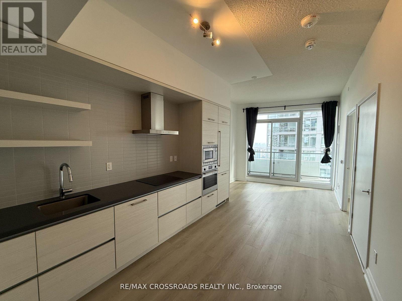 A modern kitchen with a sink, stove, and cabinets.