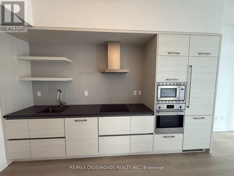 A modern kitchen with white cabinets and a black countertop.
