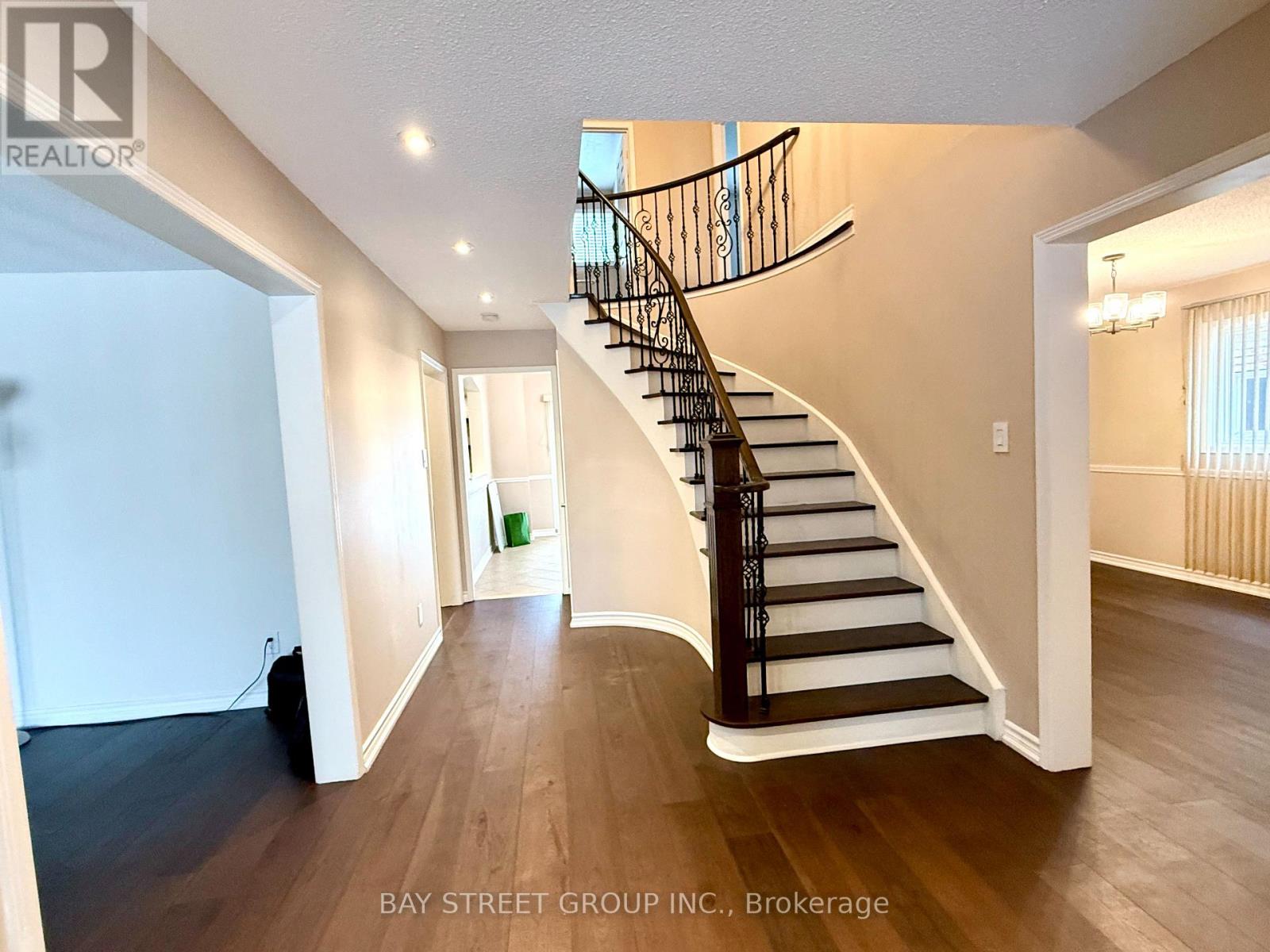A spacious room with a curved staircase and wooden flooring.