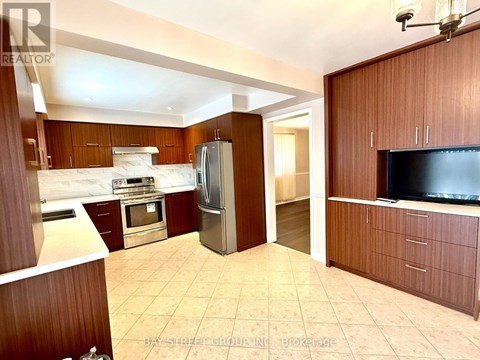 A kitchen with a refrigerator, oven, and sink.
