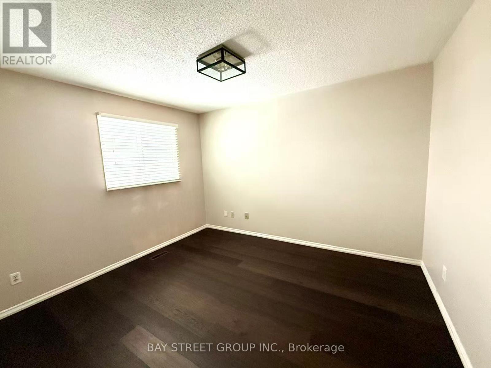 A room with a window and wooden floors is for sale.