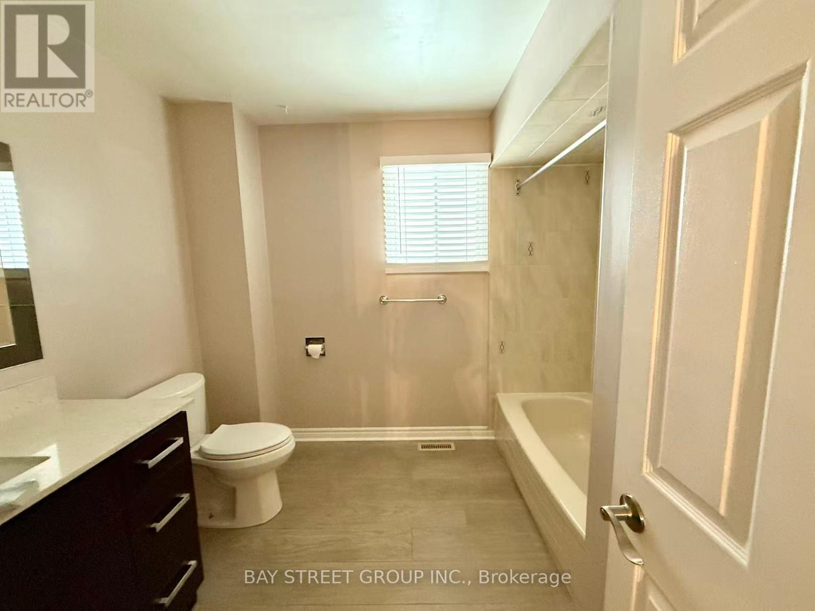A bathroom with a toilet, sink, and bathtub.