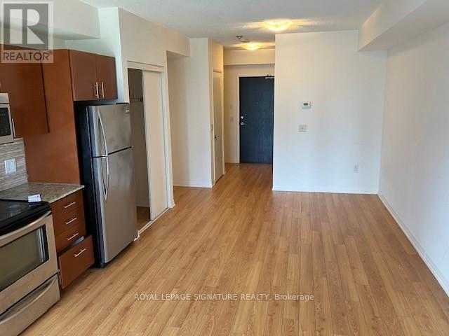 A kitchen with wooden floors and a refrigerator.