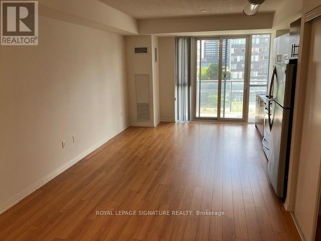 A room with wooden flooring and a sliding glass door leading to a balcony.