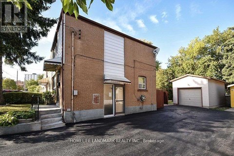 A brick building with a garage door is for sale.
