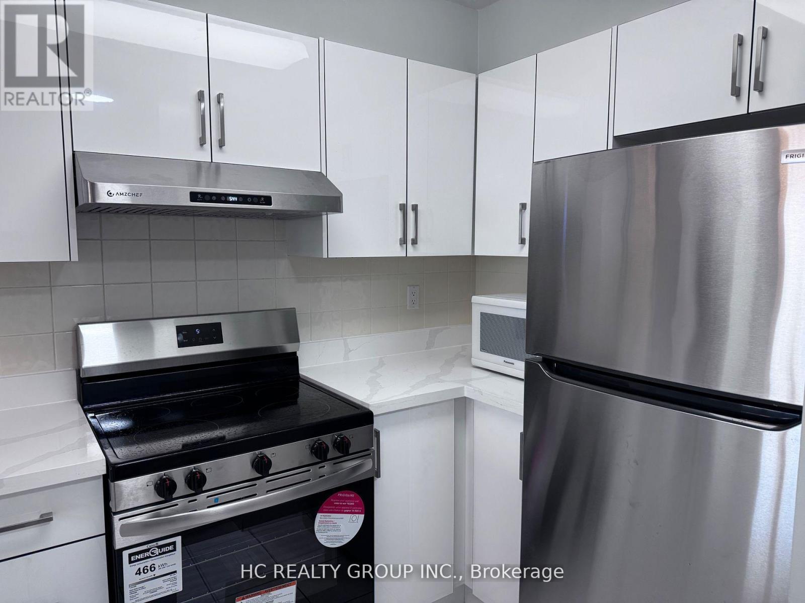 A kitchen with a stainless steel refrigerator and stove.