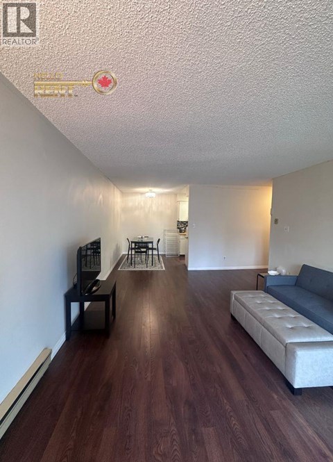 A living room with a grey couch and a wooden floor.